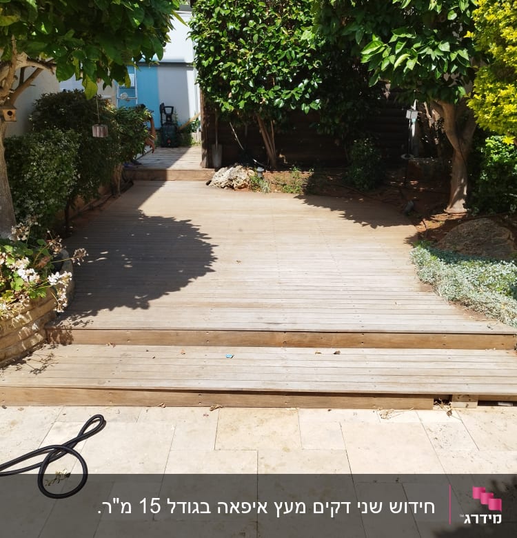 דק עץ בגינה עם צמחייה מסביב ושביל עץ